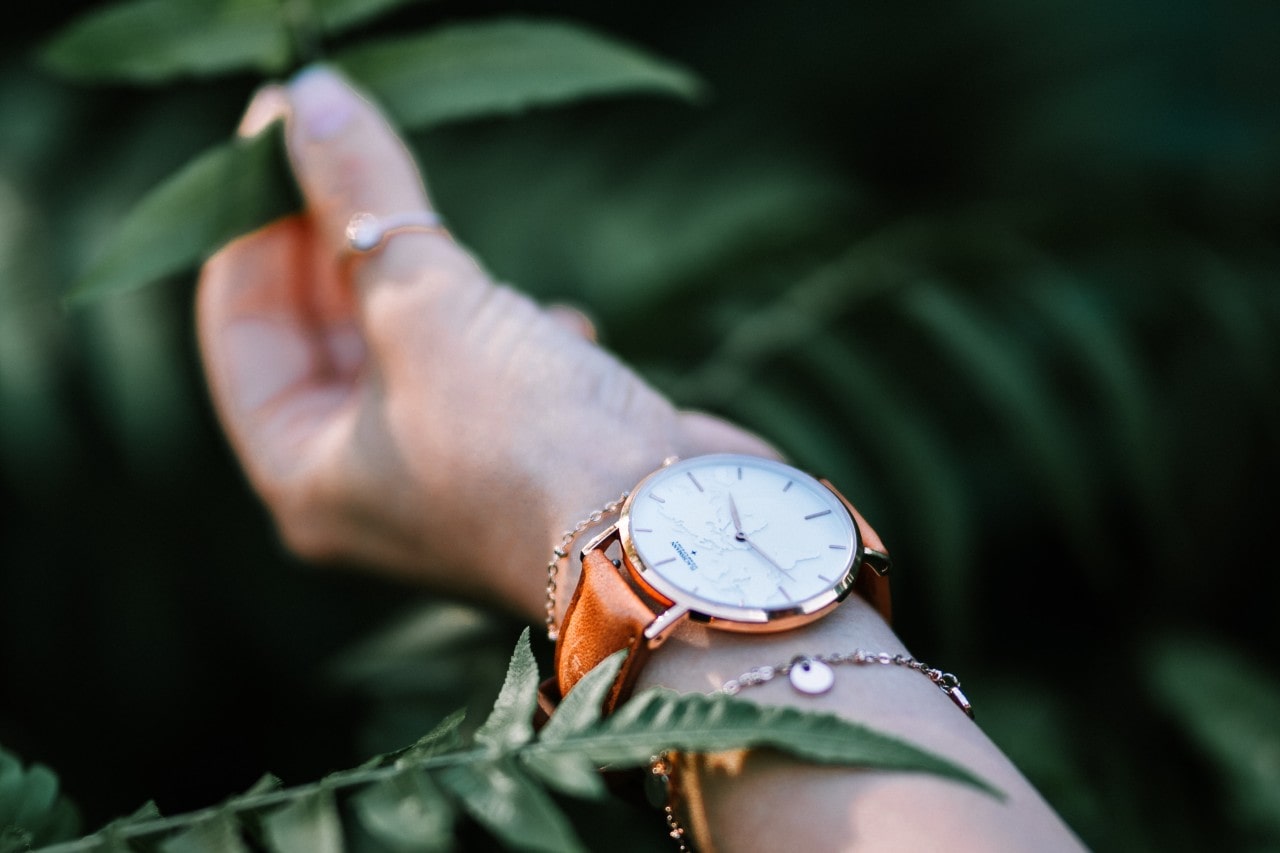 man holding plant with watch