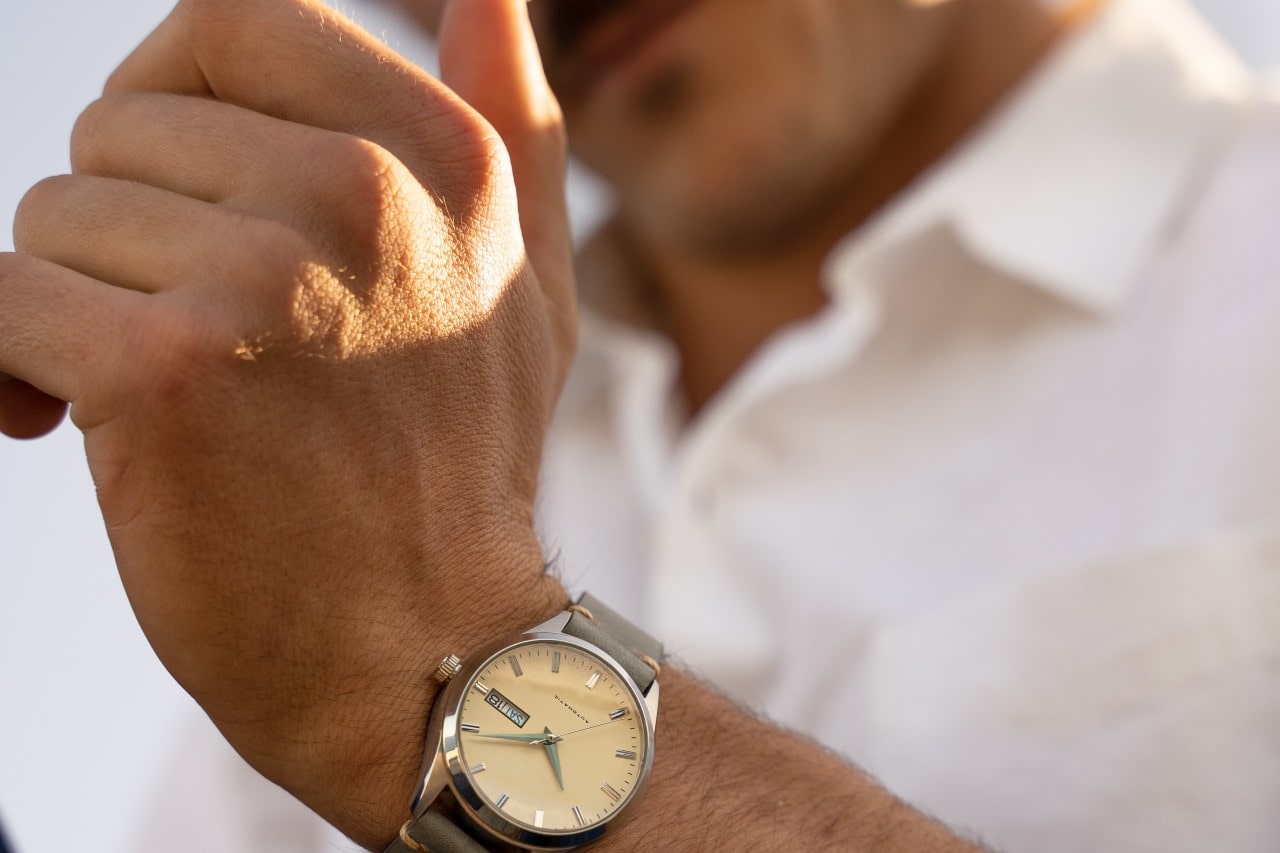 Man adjusting his silver and beige watch