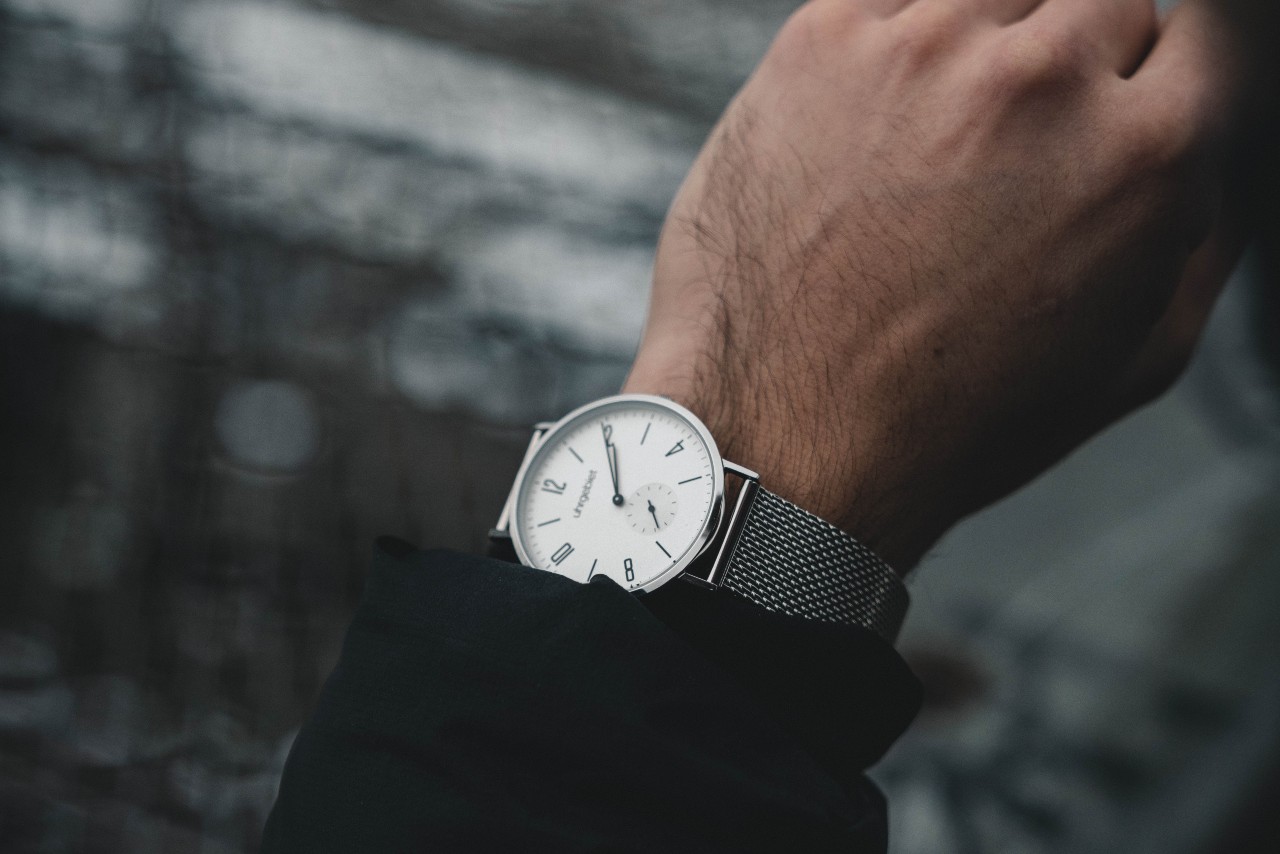 A man checks his retro-inspired watch while on a walk through the city
