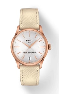 A women’s watch by Tissot with a beige leather strap and white dial