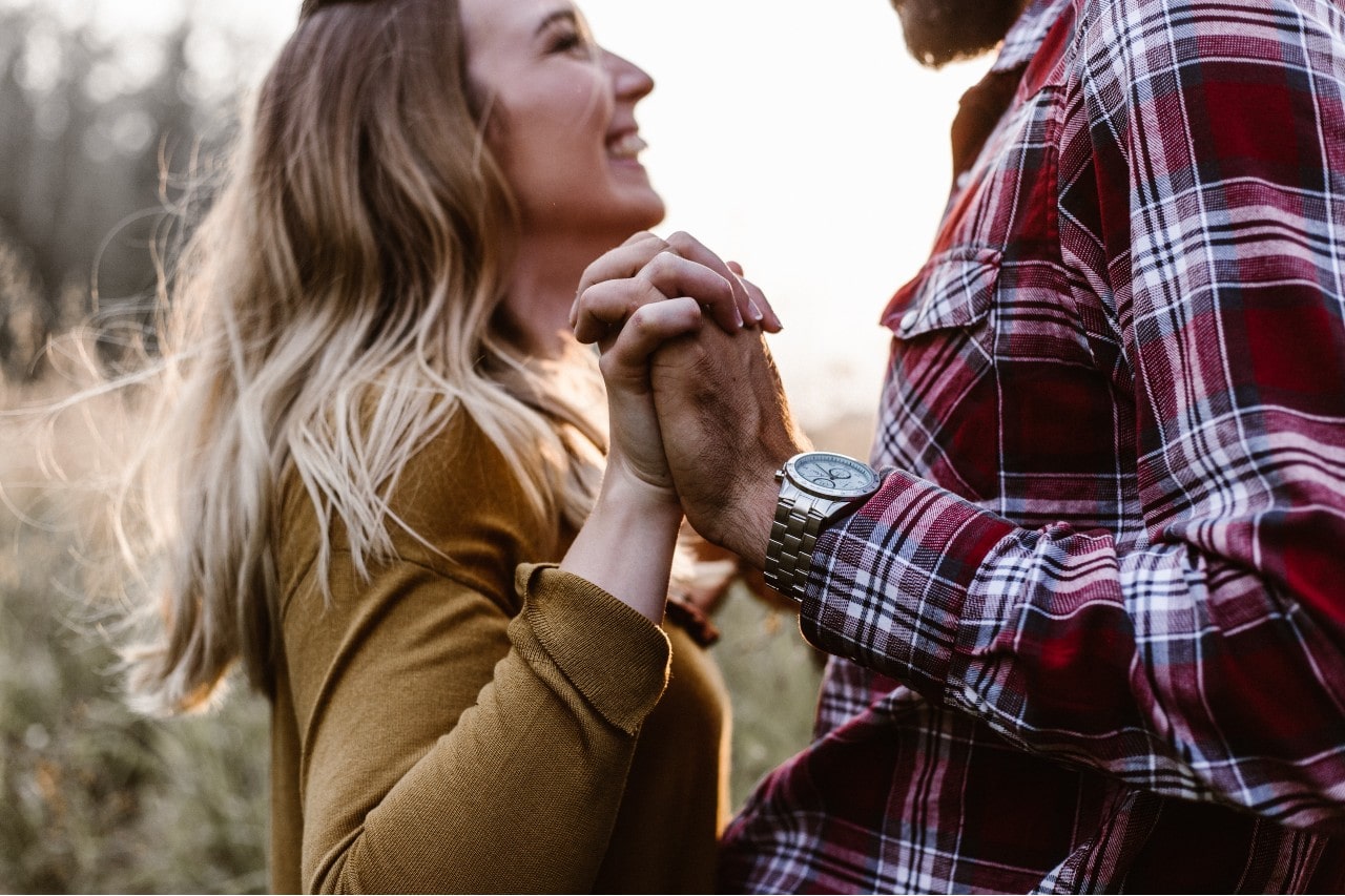 A comfortably dressed couple enjoying the autumn season, a luxury watch on his wrist.