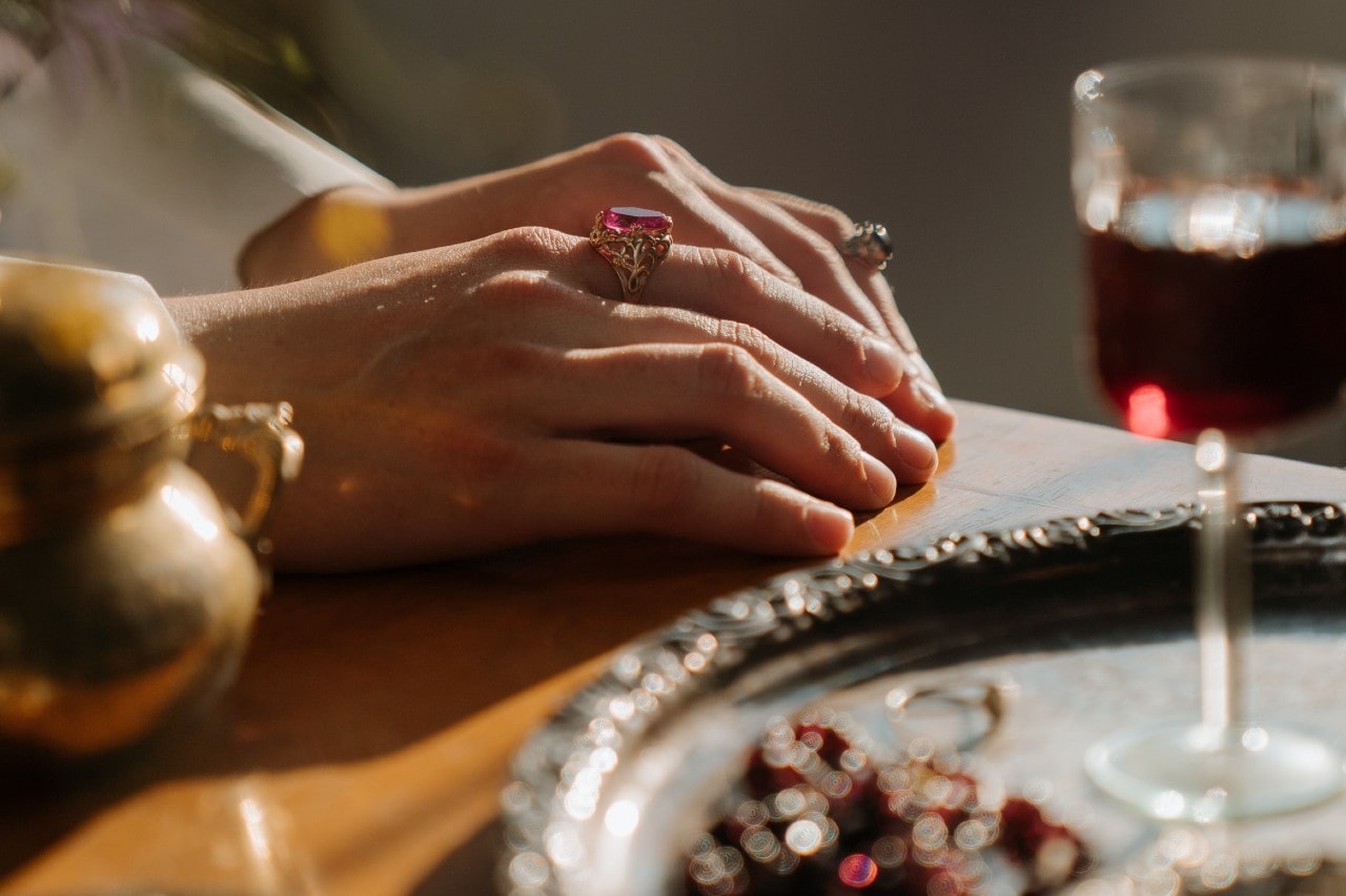 hands on table with fashion rings on them