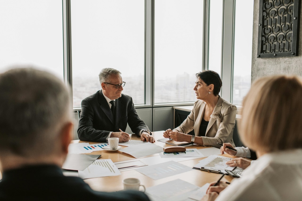 A man and woman discuss in a business meeting.