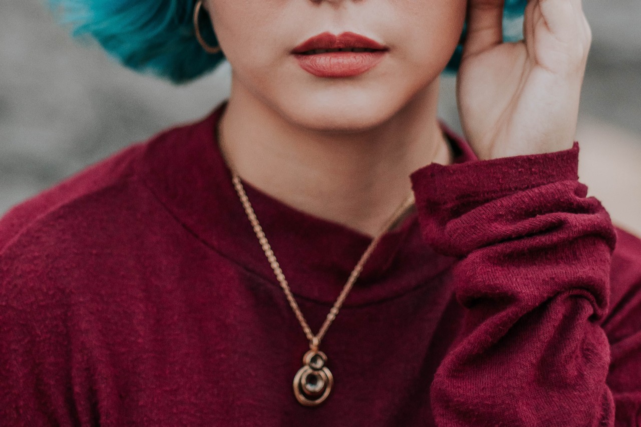 lady wearing a red sweater and rose gold necklace