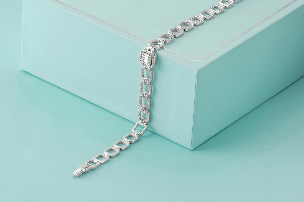 A close-up of a stunning diamond bracelet displayed on a robin’s egg blue backdrop.