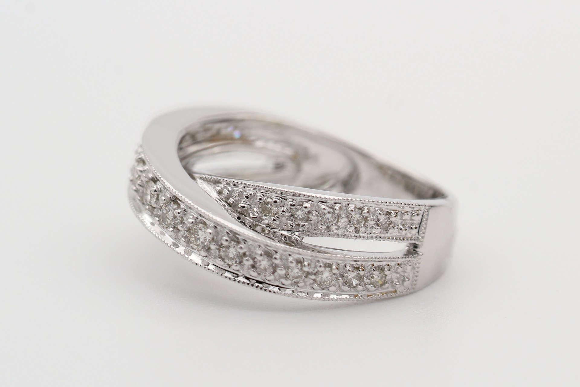 A white gold diamond fashion ring with overlapping bands.