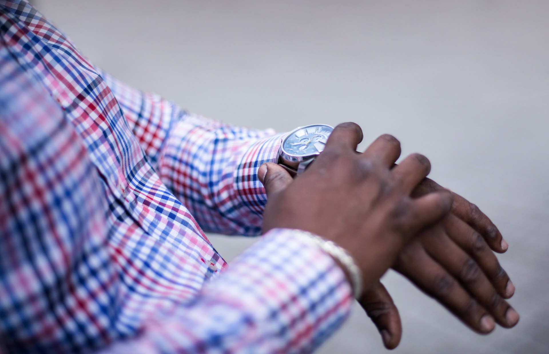 a man’s hands checking his watch