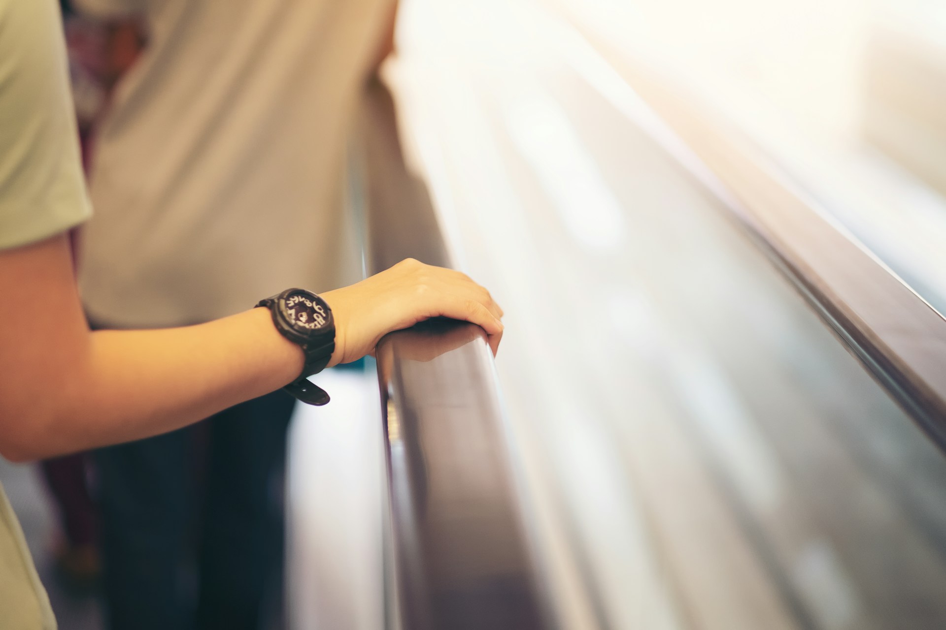 a lady’s arm resting on a handrail wearing a black watch