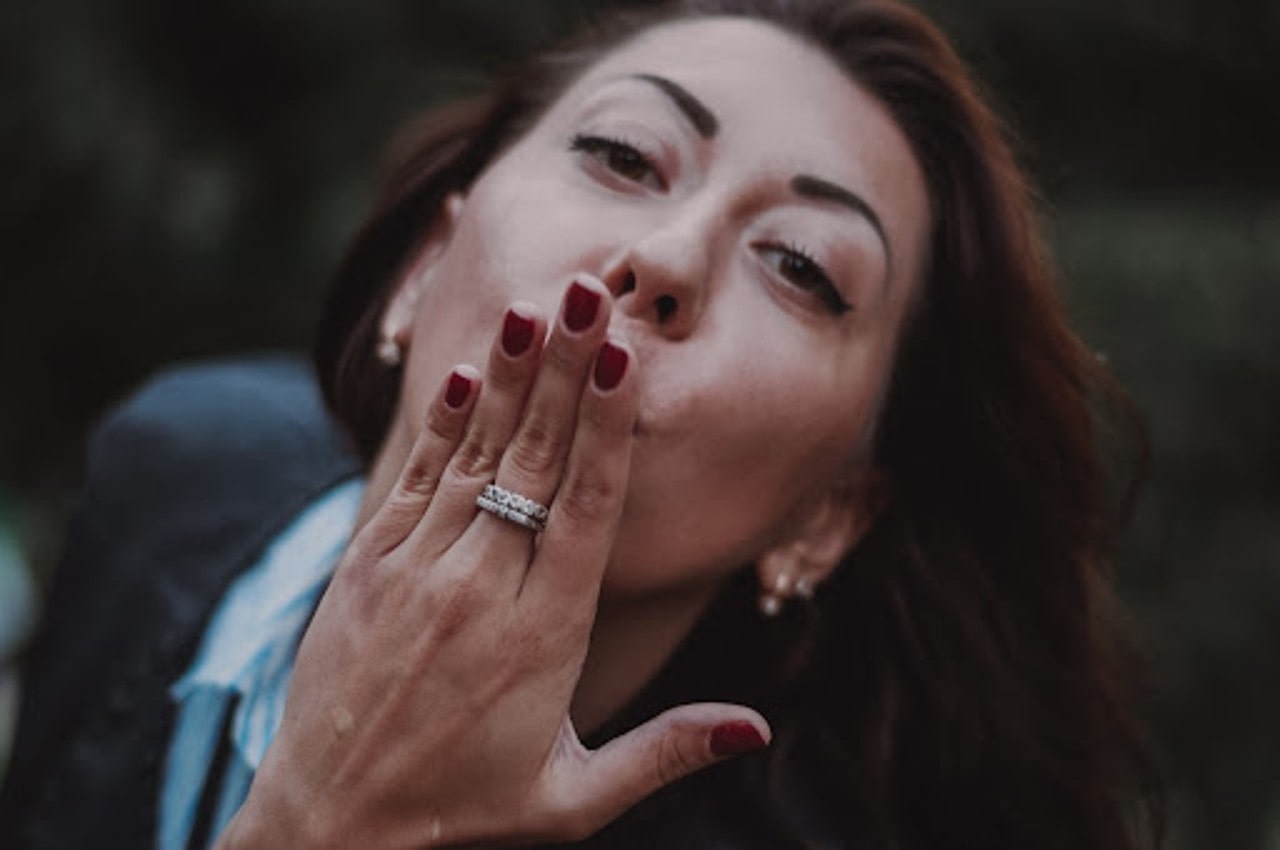 woman with fashion rings blowing a kiss