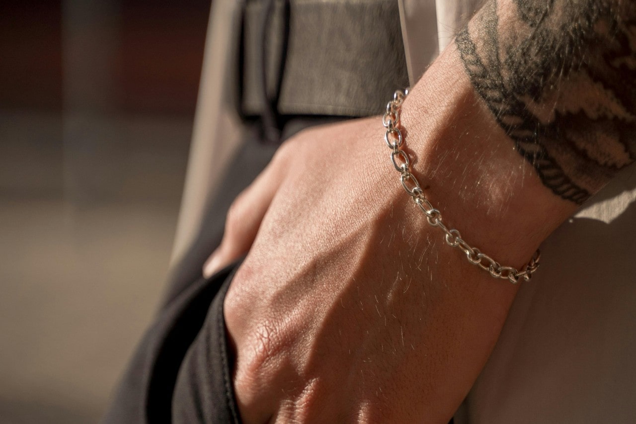 A closeup of a person’s wrist wearing a simple chain bracelet. A closeup of a person’s wrist wearing a simple chain bracelet.